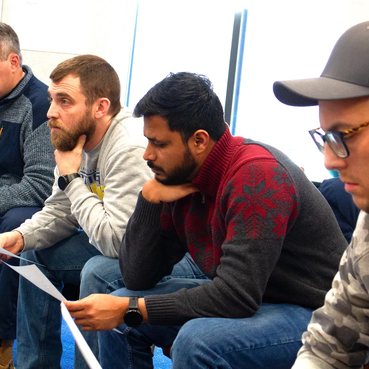A group of men sitting in front of papers.