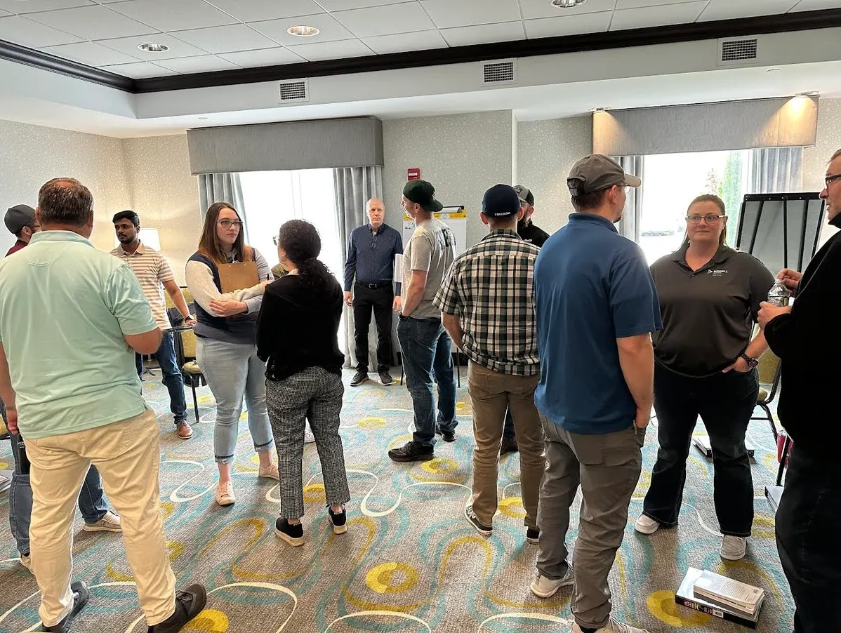 A group of people standing around in a room.