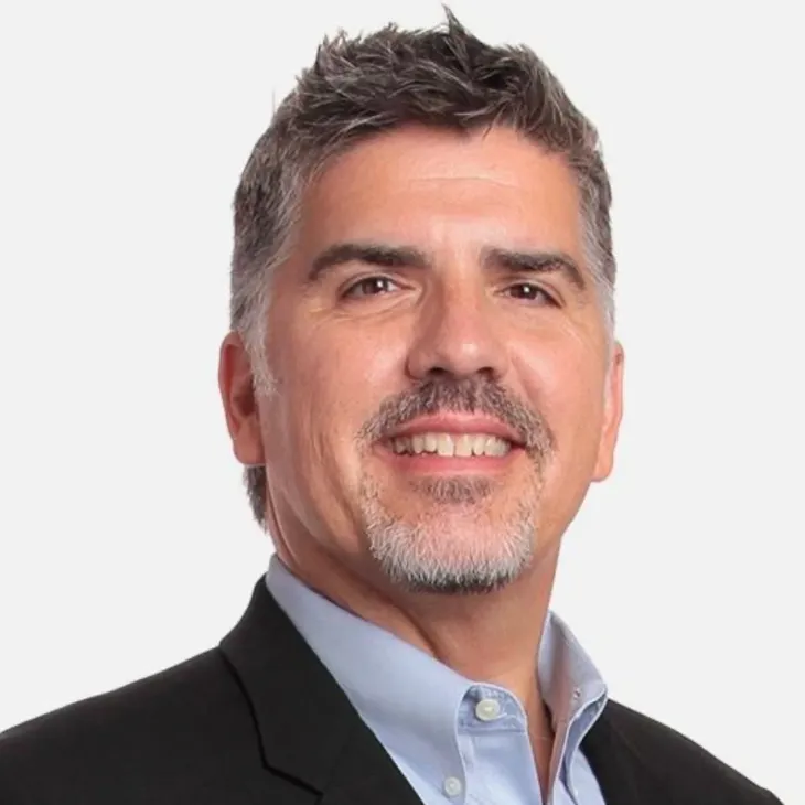 A man with grey hair and a blue shirt.