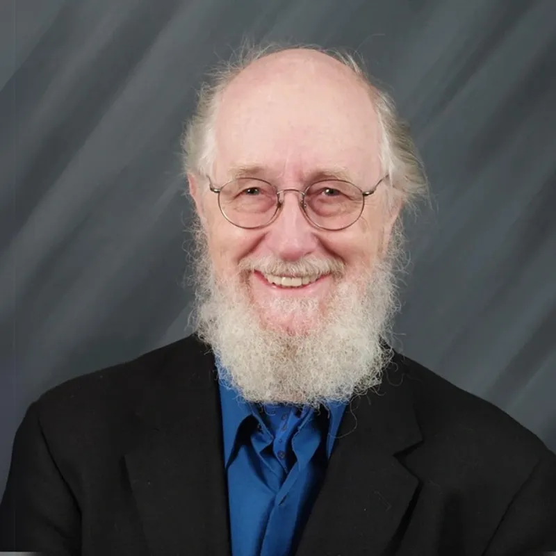 A man with a beard and glasses in a suit.